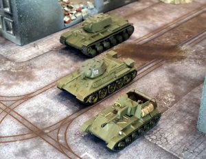 Stalingrad Linebreakers bundle: 28mm Soviet T‑34, KV‑1, and SU‑76M on urban rubble terrain.